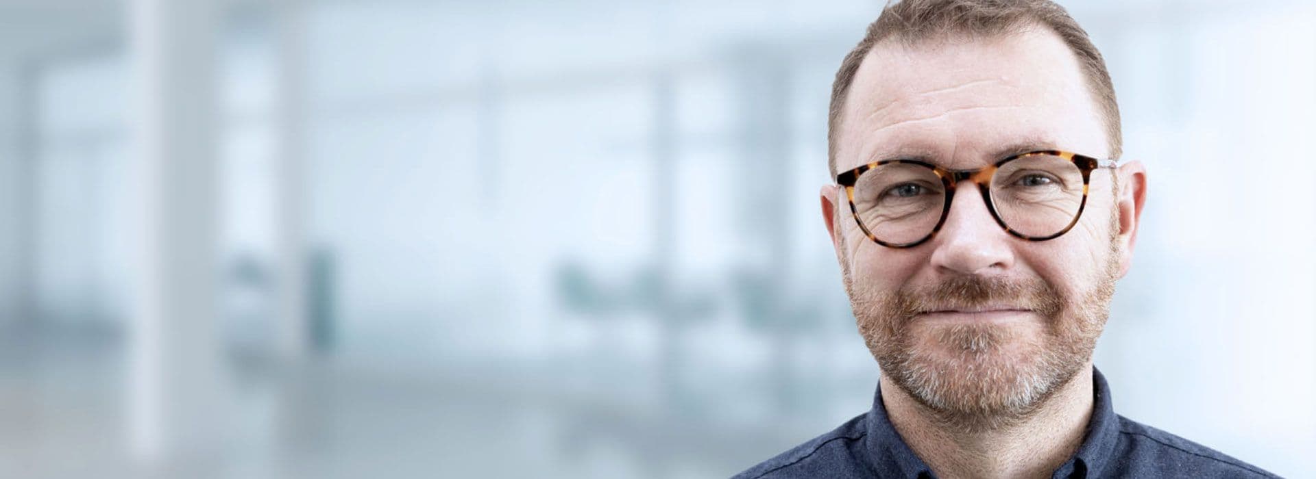 Mandlig smilende professionel inden for audiologi