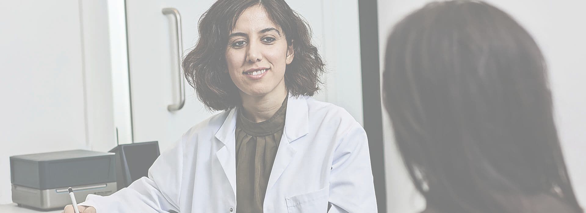 En kvindelig hørespecialist har en konsultation med en kvindelig patient